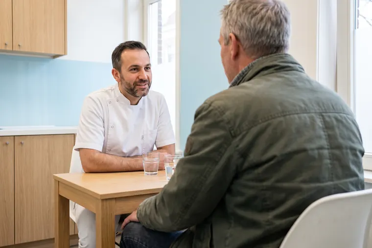 Een tandarts in gesprek met een patiënt aan een tafel